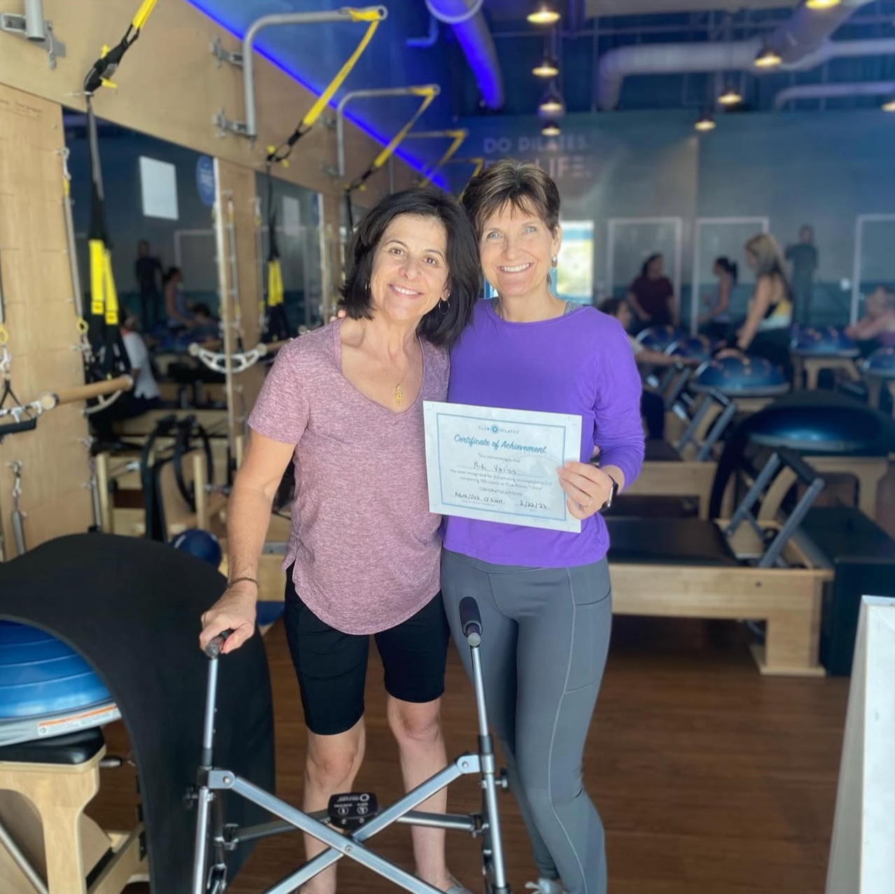 Club Pilates member success story of Niki V pictured in pilates studio with her female pilates instructor and both are smiling